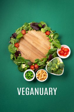Vegetarian and vegan diet month in january called Veganuary. Variety of vegan, plant based protein food, healthy raw vegetables. Top view on green background. clipart