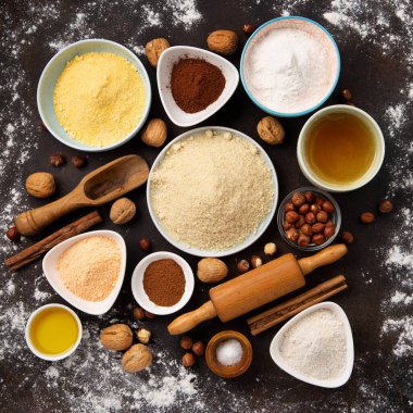 Glütensiz kurabiye ya da ekmek için gerekli malzemeler. Sağlıklı beslenme, diyet, dengeli gıda konsepti. Mısır gevreği, glütensiz darı, kinoa, badem, karabuğday, baharat, kahverengi arka planda bal. Eski tahıl yiyeceği.