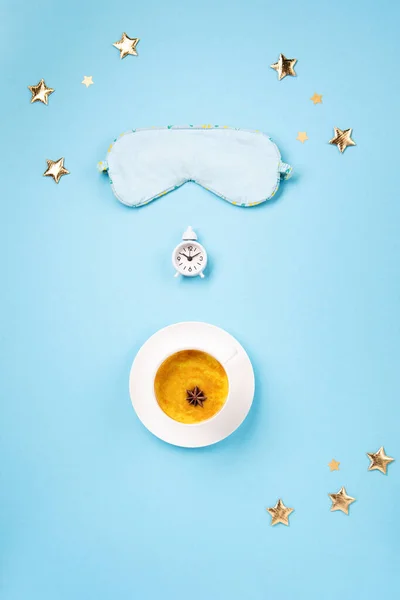 3月是世界睡眠日 睡眠质量 放松的概念 睡觉的面具 姜黄的金乳胶拿铁和蓝色背景的白色闹钟 平躺在地上 俯瞰四周 — 图库照片