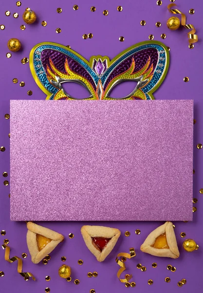 普林庆祝犹太人狂欢节的概念 采购产品味道鲜美的哈曼曲奇 三角糕点 节日狂欢节面具 甜糖果和紫色背景的聚会装饰 顶视图 复制空间 — 图库照片