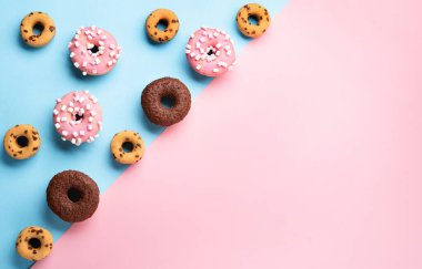 Donuts doughnuts with chocolate, marshmallow and sugar sprinkles on blue background, copy space. Colorful carnival or birthday party card. Happy National donut day Concept. 