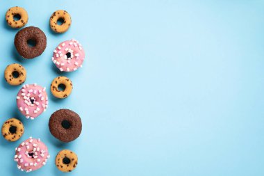 Donuts doughnuts with chocolate, marshmallow and sugar sprinkles on blue background, copy space. Colorful carnival or birthday party card. Happy National donut day Concept. 