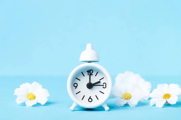 Λευκό Ξυπνητήρι Και Daisy Λουλούδια Μπλε Φόντο Spring Forward Time — Φωτογραφία Αρχείου