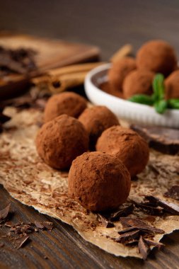 Ev yapımı vegan çikolatalı trüf, yuvarlak çikolatalı, kakao tozlu. Kaba ahşap arka planda koyu çikolata ve hindistan cevizi ezmesi. El yapımı, glütensiz, sağlıklı tatlı konsepti..