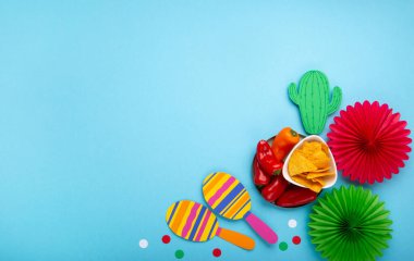 Geleneksel Meksika cipsleri, kırmızı biber, kaktüs ve marakas içeren Meksika arka plan şenliği. Cinco de Mayo (5 Mayıs) kutlama konsepti. Üst görünüm, alanı kopyala.
