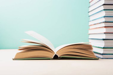 Dünya kitabı ve telif hakkı günü, eğitim konsepti. Mavi nane arkaplanıyla ilgili yığınla kitap. Kitaplar için bayram kartı, kopyalama alanı.