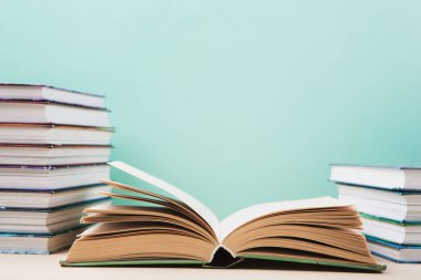 Dünya kitabı ve telif hakkı günü, eğitim konsepti. Mavi nane arkaplanıyla ilgili yığınla kitap. Kitaplar için bayram kartı, kopyalama alanı.