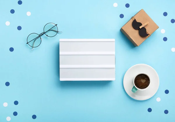 父亲节贺卡概念与工艺礼品盒 黑色胡子 一杯咖啡 空的白色灯箱和蓝色背景的眼镜 顶视图 复制空间 — 图库照片