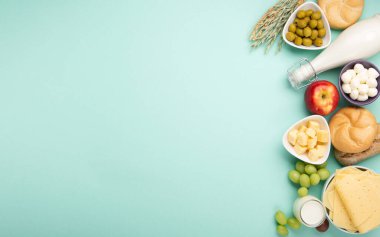 Mutlu Shavuot şenlik kartları. Yahudi dini bayramı konsepti. Süt ürünleri, meyveler, peynir, ekmek, süt şişesi, süzme peynir, naneli buğday. Üst görünüm, alanı kopyala.