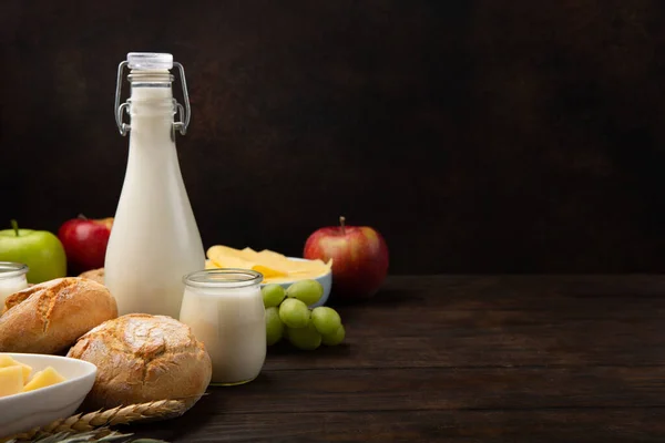 ハッピーシャヴーのお祝いカード ユダヤ教の祝日の概念 乳製品 チーズ ミルクボトル コテージチーズ 暗い木製の背景の小麦 コピースペース — ストック写真