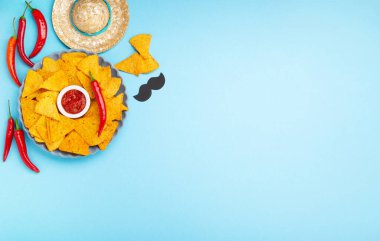 Geleneksel Meksika cipsi, acı biber ve domates soslu Meksika fiesta arka planı mavi masada. Cinco de Mayo (5 Mayıs) kutlama konsepti. Üst görünüm, alanı kopyala.