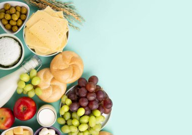 Mutlu Shavuot şenlik kartları. Yahudi dini bayramı konsepti. Süt ürünleri, meyveler, peynir, ekmek, süt şişesi, süzme peynir, naneli buğday. Üst görünüm, alanı kopyala.
