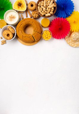 Junina Yaz Festivali Karnavalı konsepti. Brezilya hasır şapkası, Mısır keki, fıstık ve beyaz ahşap arka planda renkli bayraklar, üst manzara. Tebrik Kartı, Davetiye veya Tatil Posteri Tasarımı