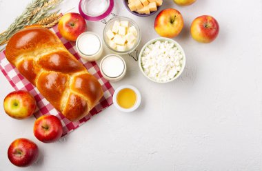 Mutlu Shavuot şenlik kartları. Yahudi dini bayramı konsepti. Süt ürünleri, taze elma, peynir, ekmek, süt, süzme peynir, buğday ve bal. Üst görünüm, alanı kopyala.
