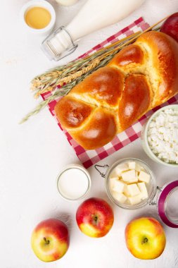 Mutlu Shavuot şenlik kartları. Yahudi dini bayramı konsepti. Süt ürünleri, taze elma, peynir, ekmek, süt, süzme peynir, buğday ve bal. Üst görünüm, alanı kopyala.