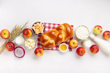 Mutlu Shavuot şenlik kartları. Yahudi dini bayramı konsepti. Süt ürünleri, taze elma, peynir, ekmek, süt, süzme peynir, buğday ve bal. Üst görünüm, alanı kopyala.