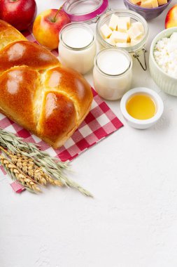 Mutlu Shavuot şenlik kartları. Yahudi dini bayramı konsepti. Süt ürünleri, taze elma, peynir, ekmek, süt, süzme peynir, buğday ve bal. Üst görünüm, alanı kopyala.