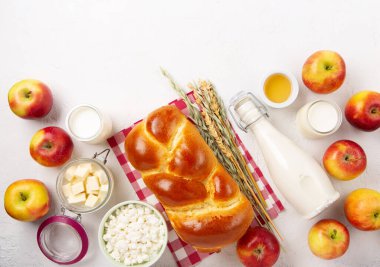 Mutlu Shavuot şenlik kartları. Yahudi dini bayramı konsepti. Süt ürünleri, taze elma, peynir, ekmek, süt, süzme peynir, buğday ve bal. Üst görünüm, alanı kopyala.