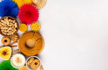 Junina Yaz Festivali Karnavalı konsepti. Brezilya hasır şapkası, Mısır keki, fıstık ve beyaz ahşap arka planda renkli bayraklar, üst manzara. Tebrik Kartı, Davetiye veya Tatil Posteri Tasarımı