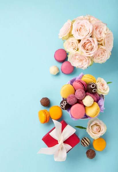 Zoete Koekjes Macarons Rode Geschenkdoos Rozenbloemen Chocolade Snoepjes Blauwe Achtergrond — Stockfoto