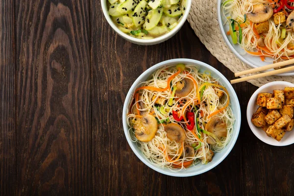 豆腐とビーガン米麺 ピーマン ニンジンとズッキーニダークブラウンの背景に中華鍋の準備 トップビュー 健康的なビーガンフードコンセプト — ストック写真