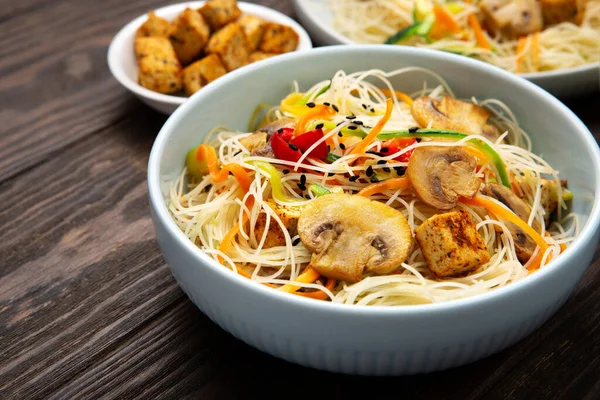 豆腐とビーガン米麺 ピーマン ニンジンとズッキーニダークブラウンの背景に中華鍋のために準備 健康的なビーガンフードコンセプト — ストック写真