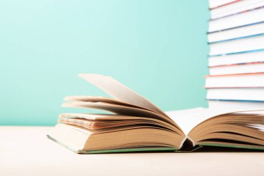 Okula, eğitime, okumayı seviyorum. Mavi nane arkaplanı üzerine kitap ve kitap yığınını aç, boşluğu kopyala.