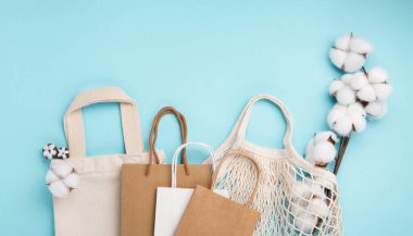 Uluslararası plastik poşetsiz gün konsepti. Sürdürülebilir ve ekoloji yaşam tarzı. Plastiğe hayır de. Yeşile git. Doğayı kurtar. Yeniden kullanılabilir ve geri dönüşüm kağıdı, tekstil pamuk torbaları, mavi arka planda ağ torbaları