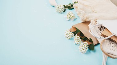 Uluslararası plastik poşetsiz gün konsepti. Üzerinde yaz çiçekleri olan yeniden kullanılabilir kağıt torba mavi arka planda tekstil pamuk ağ torbaları. Sürdürülebilir Ekoloji yaşam tarzı. Plastiğe hayır de Yeşile git Doğayı kurtar. 