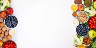 Sağlıklı vejetaryen yaşam tarzı, dengeli gıda, beslenme, temiz yemek kavramı. Beslenme için taze malzemeler, sebzeler, meyveler, beyaz masada kilo vermek için fındıklar. Sağlıklı arkaplan, üst görünüm.