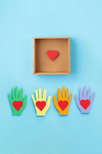 World Humanitarian Day Concept. Tolerance, kindness, cooperative, friendship, charity, humanitarian aid day concept. Red Hearts and donation box on blue background, copy space, top view.