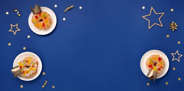传统的国王日用面包 蓝色背景的艾皮芬尼蛋糕 冬季装饰 Roscon Reyes 西班牙三个国王圣诞甜饼 西班牙的典型甜食埃皮芬尼的一天 顶部视图 图库照片