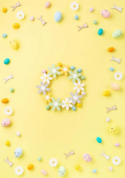 Süße Bunte Ostereier Und Weiße Gänseblümchenblümchen Auf Pastellgelbem Hintergrund Frohe lizenzfreie Stockbilder