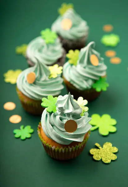 圣帕特里克节香草和巧克力杯蛋糕绿色泡沫和闪亮的三叶草装饰绿纸背景 爱尔兰假日甜点概念 复制空间 图库照片