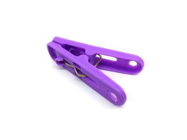 Plastic clothes pin isolated on white background. Close up of purple clothes peg.