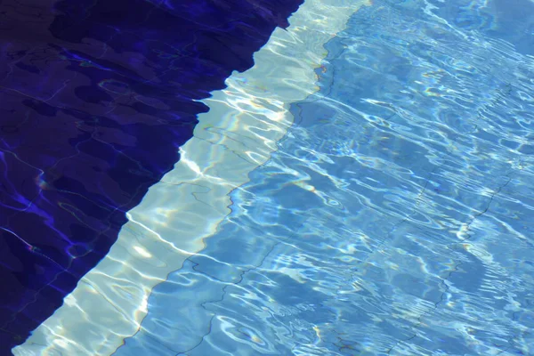 wave pool water with blue floor mat and reflection of stripes