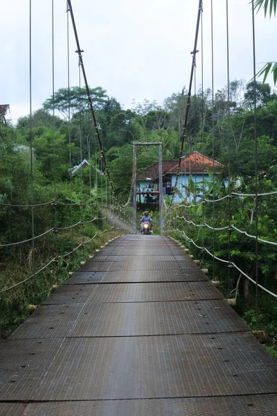 Ponte Suspensão Sobre Rio Com Motocicleta Cruzando Sobre Ele Pela — Fotografia de Stock