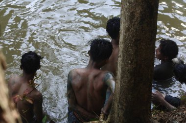central java, Indonesia -June 10, 2022: Panjat Pinang Greasy Pole over the river. Indonesian People Celebrating the earth's alms after the harvest (sedekah bumi)
