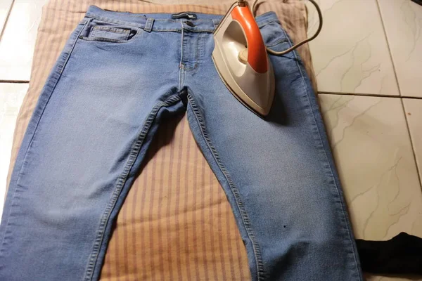 hand ironing jeans. laundry business concept.