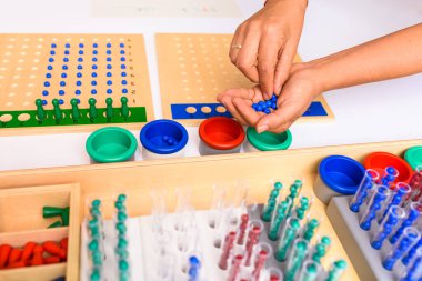 Montessori yönetim kurulu bölümünün ayrıntıları. Bir rehber ve öğretmenin eliyle operasyonun nasıl yapılacağını gösteriyor..