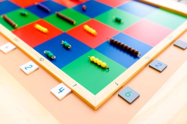 Montessori malzemelerinin ayrıntıları, karoları ve boncukları olan bir dama tahtası..