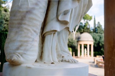 Klasik bir Yunan bahçesinin arka planında odak dışı bir mermer heykelin ayrıntıları.