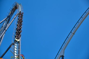 Valencia, İspanya - 20 Mayıs 2022: Uzun, ince bir metal yapı güneşli bir yaz gününde eğlenceli bir hız trenini destekler..