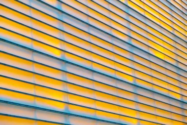 Background of yellow symmetrical lines with real lighting on a wall