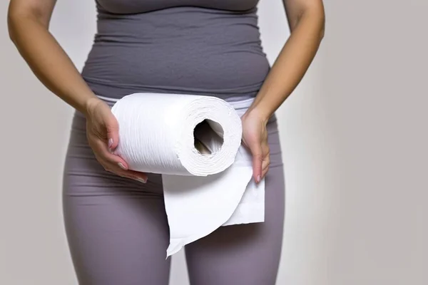 女性は腹までトイレ紙のロールを保持します — ストック写真