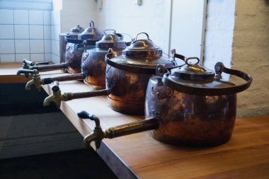 Eski mutfak eşyaları ve antika tencereler eski çağlardan kalma tarihi bir mutfak sergisinde sergileniyor.