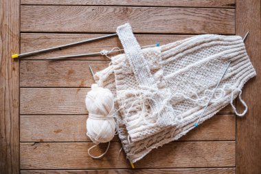 Örgü iğneleriyle dokunmuş beyaz yünden bir elbise.