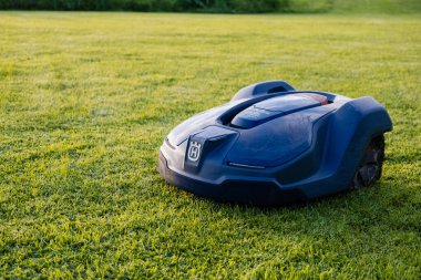 Mayıs, İrlanda - Ağustos 2023: Gelişmiş bir otomatik çim biçme makinesi, yemyeşil çimenleri zahmetsizce korumak için robotikleri kullanıyor