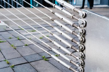 Çelik, yere doğru itilen desteğe bağlı kalır. Bir köprünün çelik kablolarını tutun..