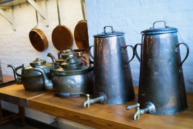 Eski mutfak eşyaları ve antika tencereler eski çağlardan kalma tarihi bir mutfak sergisinde sergileniyor.